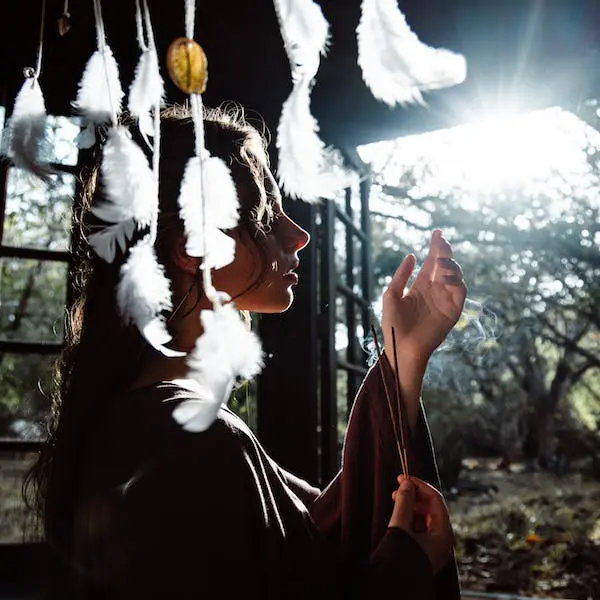 Photo of Sonya practicing shamanic breathwork with dreamcatcher in foreground
